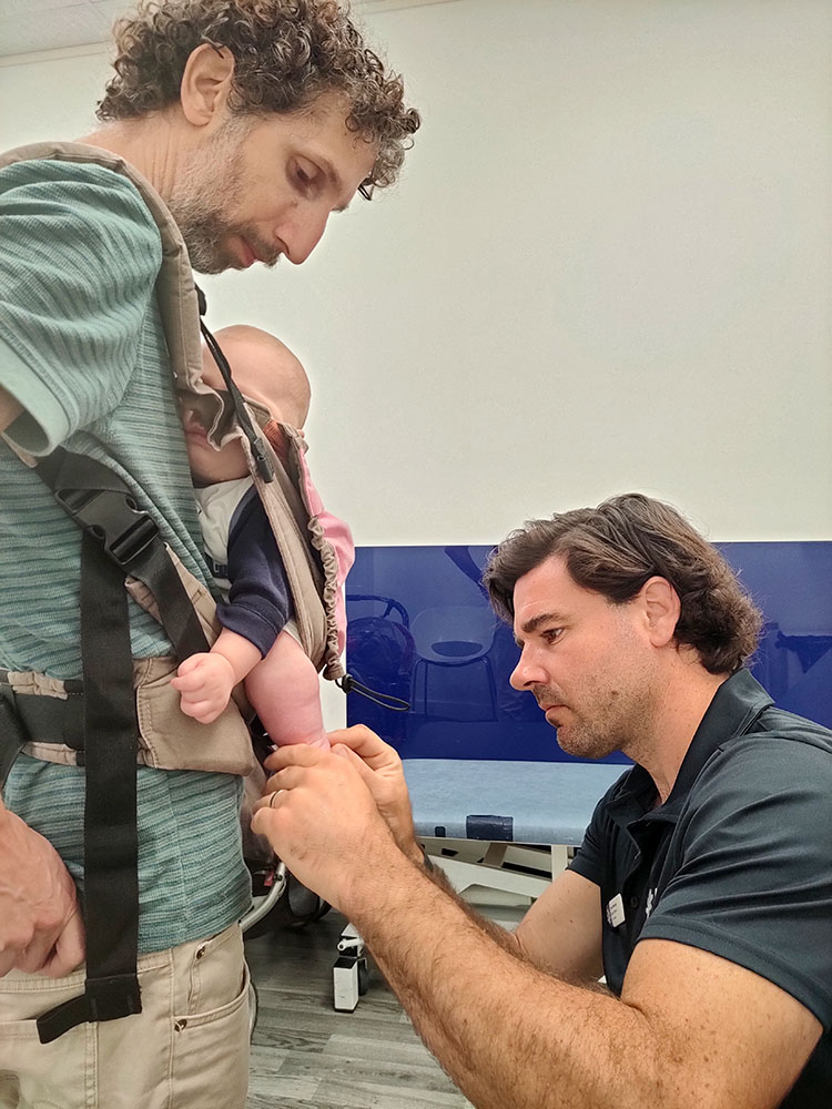 Orthotist Sam Walmsley assesses baby Tal for club foot in clinic