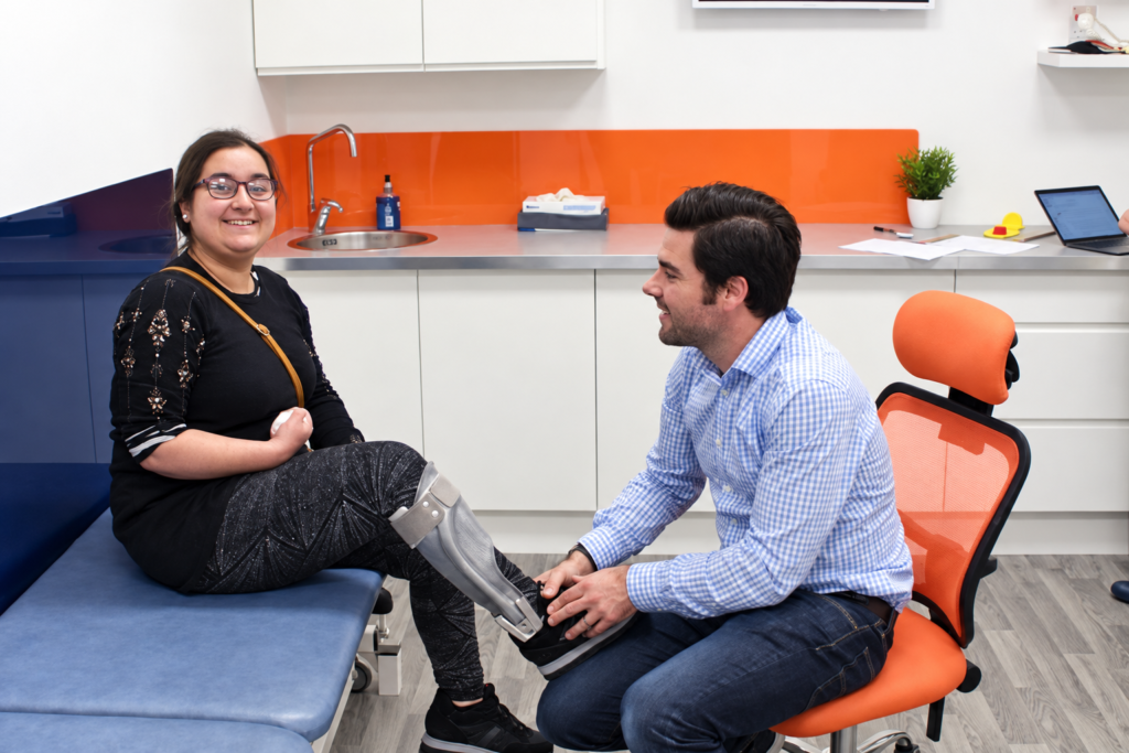 An LOC orthotist fitting a bespoke lower-limb orthosis for a patient